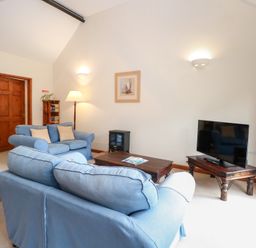 A living room with a sofa and television at Holly Berry in Wood Norton near Foulsham