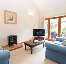 A living room with a sofa and television at Holly Berry Wood Norton near Foulsham