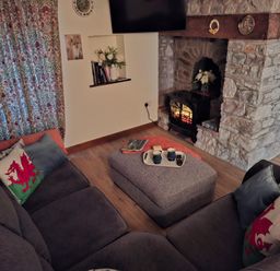 A living room with a sofa and a fireplace at Dolcoed in Llandeilo