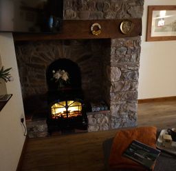 A living room with a fireplace and television at Dolcoed in Llandeilo