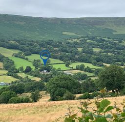 A rural landscape with green fields trees and hills at White Haywood Farmhouse & Barn in Craswall