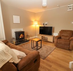 A living room with a fireplace and television at O'Connell's Lodge, Portmagee, County Kerry