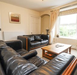 A living room with a sofa and coffee table at Sygun Cottage in Nant Gwynant