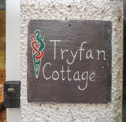 A sign displaying Tryfan Cottage located at Tryfan Cottage in Nant Gwynant