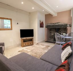 A living room with a TV and a dining area at Tryfan Cottage in Nant Gwynant