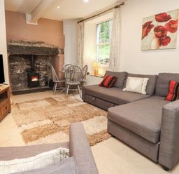 A living room featuring a sofa, tv, and fireplace at Tryfan Cottage in Nant Gwynant