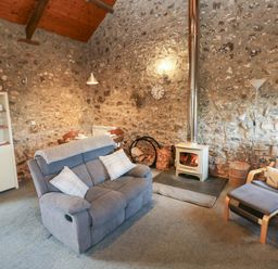A living room with a sofa and fireplace at 8 Rogeston Cottages in Haverfordwest
