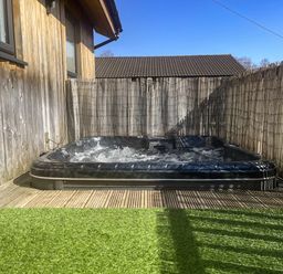 An outdoor area with a hot tub at Woodburn Lodge in Otterburn