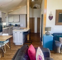 A kitchen with a table and chairs and a sofa at Woodburn Lodge in Otterburn