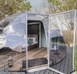 A transparent dome with an open door showing a bedroom inside at Number 1 Dome in Derrybeg County Donegal