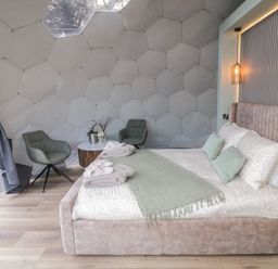 A bedroom with a bed green chairs and a small round table inside a geodesic dome at Number 1 Dome in Derrybeg County Donegal