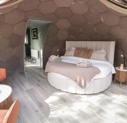 A bedroom with a round bed two side tables and two chairs at Number 2 Dome in Derrybeg County Donegal