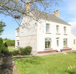 A two story house with a garden and pathway surrounded by hedges at Burry House in Llanmorlais