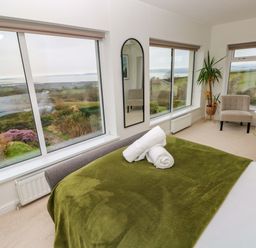 A bedroom with a bed and a plant at Burry House in Llanmorlais