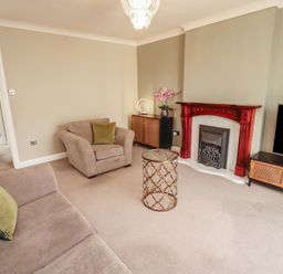 A living room with a sofa and fireplace at 3 Hawk Place Moresby Parks near Whitehaven