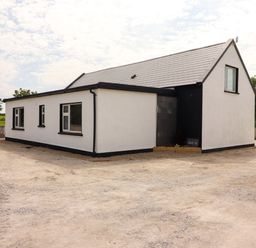 A house with a sloped roof and windows at Teach Ti in Miltown Malbay