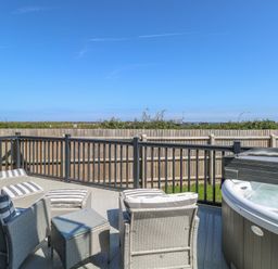 An outdoor space with chairs and hot tub at Life's a Beach in Bacton