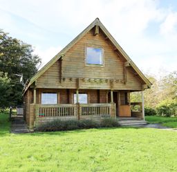 A wooden house with a porch and grass area at Pen Y Clawdd near Beggar's Bush Presteigne