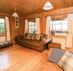 A living room with a sofa and armchair at Dan Y Coed in Beggar's Bush near Presteigne