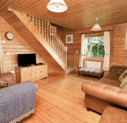 A living room with a sofa and television at Dan Y Coed in Beggar's Bush near Presteigne