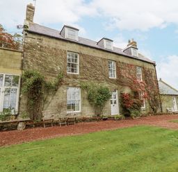 A building with windows and garden at Elford Farmhouse Seahouses