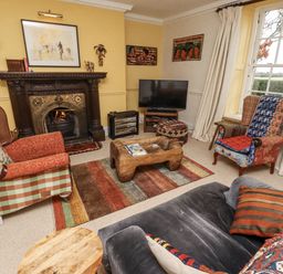 A living room with a fireplace and television at Elford Farmhouse, Seahouses