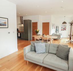 A living room with a sofa and dining table at The Lodge in Bridgend