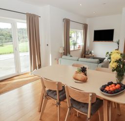 A dining room with a table and chairs at The Lodge in Bridgend