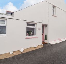 An exterior view of a house with a pink door at Penwyn in Solva