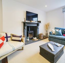 A living room with a fireplace and seating area at Church Hill House in Port Isaac