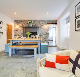 A dining room with a table and bench at Church Hill House in Port Isaac