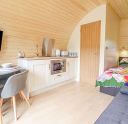 A compact wooden room with kitchenette dining table bed and sofa at Briallen in Bontddu near Dolgellau