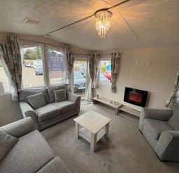 A living room with sofas and a wall-mounted fireplace at Caravan 941 in Clacton-On-Sea