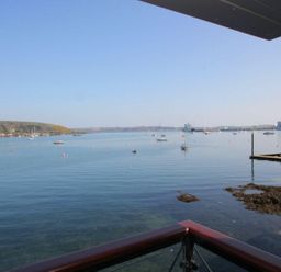 A view of a harbor with boats on water seen from a balcony at Tobys Quay in Falmouth