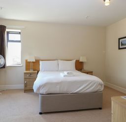 A bedroom with a bed and nightstand at Bedroom 10 in Littlehampton