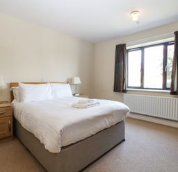 A bedroom with a bed, nightstand, and chair at Bedroom 9 in Littlehampton