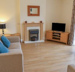 A living room with a sofa and television at Bungalow 15 Eamont Park in Penrith