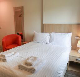 A bedroom with a bed and chair at Bedroom 7 in Penrith