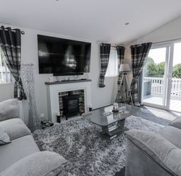 A living room with a television and fireplace at Number 42 in Wemyss Bay