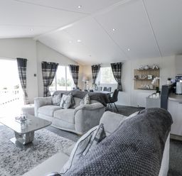 A living room with a sofa and dining area at Number 42 in Wemyss Bay