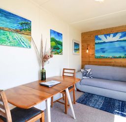 A living room with a table, chair and sofa at The Studio in Feock near Truro