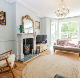A living room with a fireplace and a sofa at 18 Pakefield Road in Lowestoft