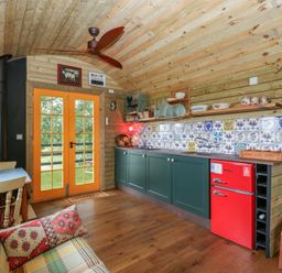 A kitchen with a red fridge and cabinets at Shepherd Hut’s in Bristol