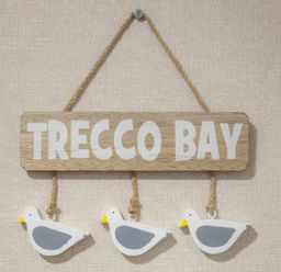 A wooden sign reading Trecco Bay with three seagull decorations at Pines 15 Porthcawl