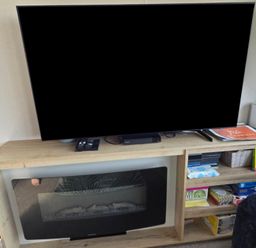 A living room with a television and entertainment unit at Pines 15 in Porthcawl