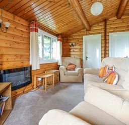 A living room with sofa and television at Y Bwthyn Pren, Cabin 209, Trawsfynydd