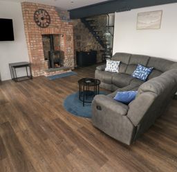 A living room with a sofa and fireplace at 10 Brython Place in Tackley