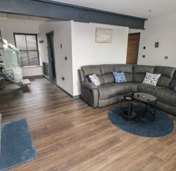 A living room with a sofa and a coffee table at 10 Brython Place Tackley