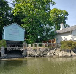 A house and a boat house by the water at The Sharpham Boat House in Ashprington