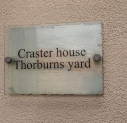 A sign for Craster House at Thorburns Yard in Seahouses